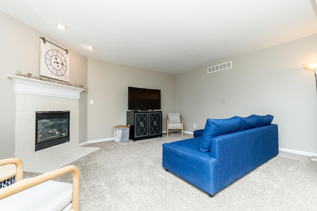 carpeted living area featuring a fireplace, visible vents, and baseboards