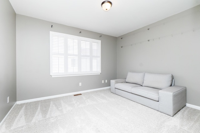 unfurnished room with carpet, visible vents, and baseboards