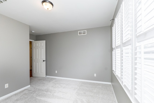 carpeted empty room featuring visible vents and baseboards