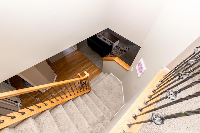 stairs featuring wood finished floors and baseboards