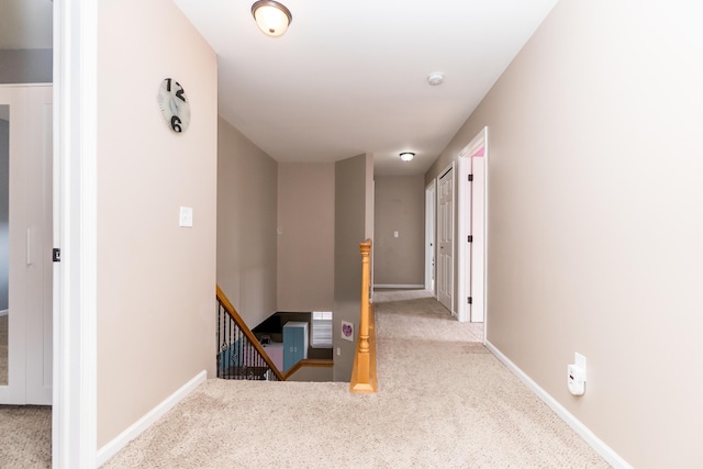 corridor with carpet, an upstairs landing, and baseboards