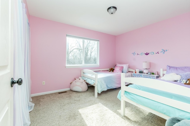 carpeted bedroom with visible vents and baseboards