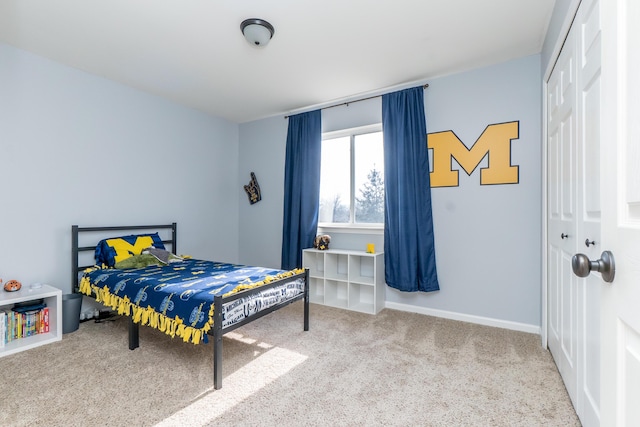 bedroom with a closet, carpet flooring, and baseboards