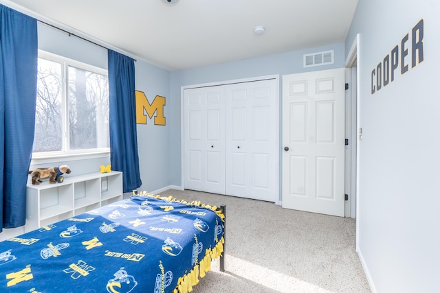 bedroom with a closet, visible vents, and baseboards