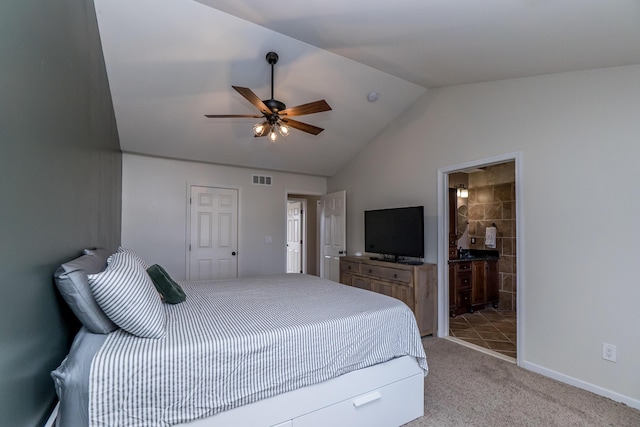 bedroom with baseboards, visible vents, light colored carpet, lofted ceiling, and ensuite bathroom