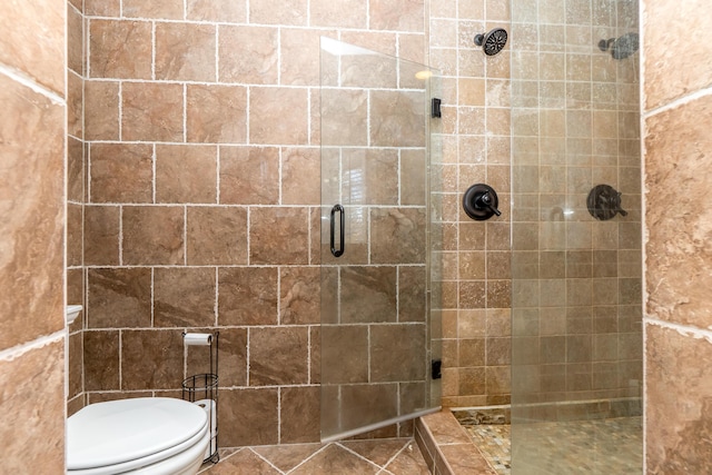 full bath featuring a stall shower and toilet