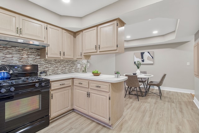 kitchen featuring light countertops, light wood-style flooring, black gas range oven, light brown cabinetry, and under cabinet range hood