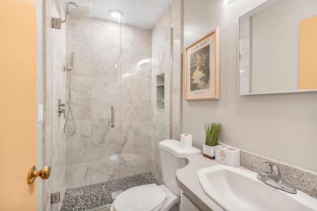 bathroom with a stall shower, vanity, and toilet