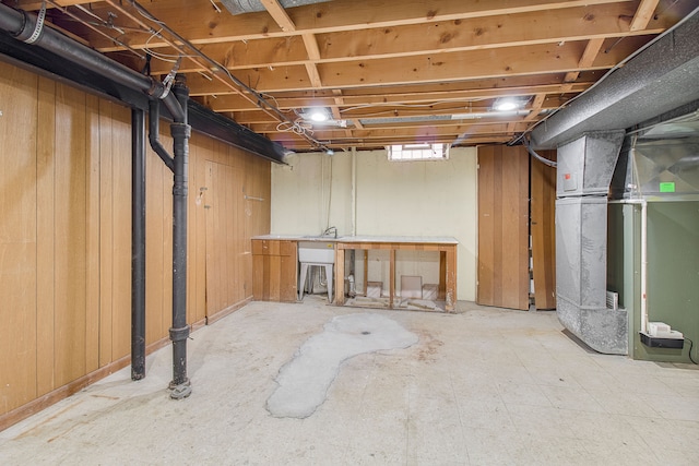 basement featuring heating unit and a sink