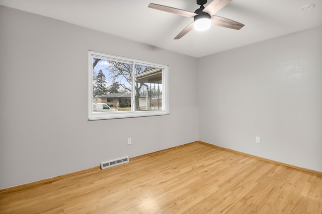 empty room with visible vents, ceiling fan, baseboards, and wood finished floors