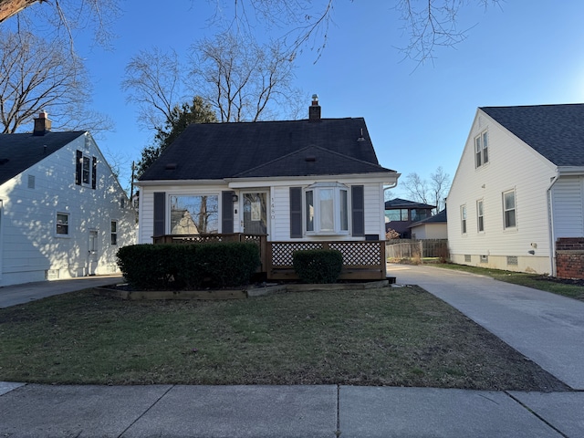 view of front of home with a chimney, a front lawn, and concrete driveway