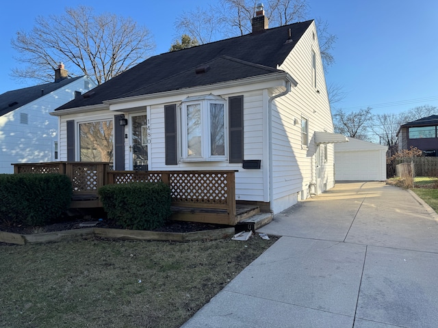 view of front of property with a garage, an outdoor structure, a chimney, and a deck