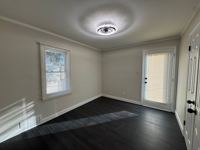 empty room with dark wood-style floors, baseboards, and crown molding