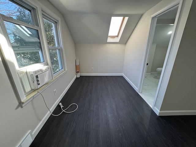 bonus room with cooling unit, dark wood-style flooring, visible vents, baseboards, and lofted ceiling with skylight