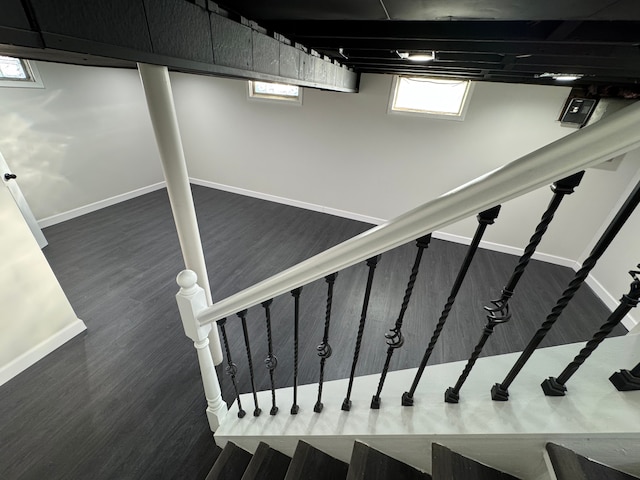 staircase featuring wood finished floors and baseboards