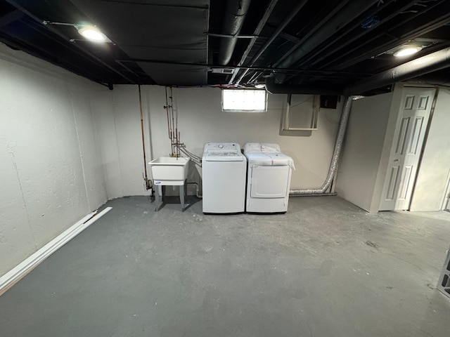 basement featuring washer and clothes dryer and a sink