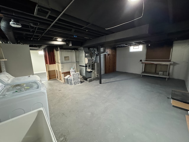 basement featuring heating unit, visible vents, and washer and dryer