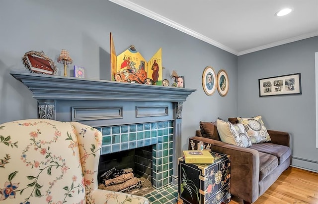 details with a tiled fireplace, a baseboard radiator, wood finished floors, crown molding, and recessed lighting