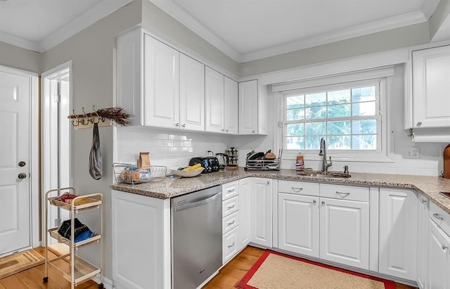 kitchen featuring a sink, white cabinetry, stainless steel dishwasher, backsplash, and crown molding