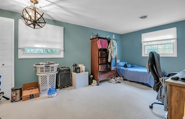 carpeted home office featuring an inviting chandelier and visible vents