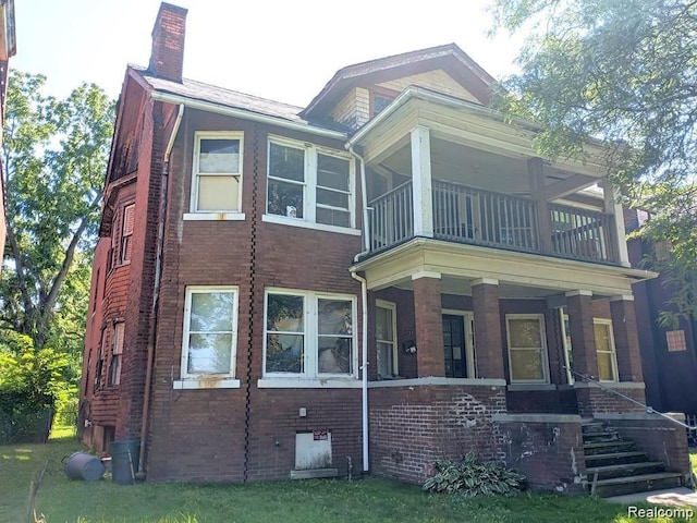 view of front of property featuring brick siding, a chimney, covered porch, crawl space, and a balcony