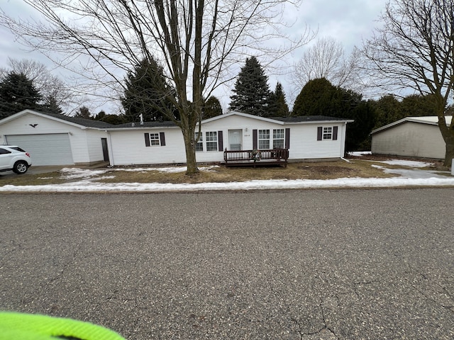 view of front of home with a garage, an outdoor structure, and a wooden deck