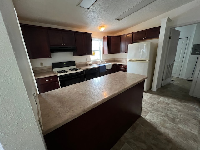 kitchen featuring dark brown cabinetry, range with gas cooktop, lofted ceiling, freestanding refrigerator, and under cabinet range hood