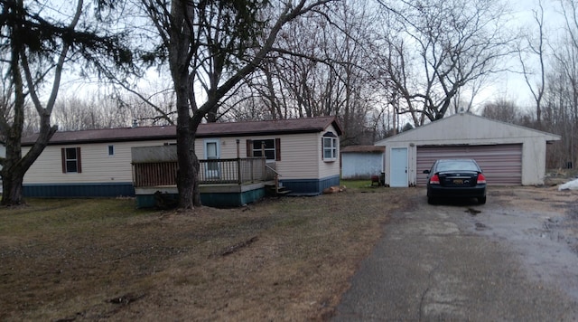 view of front of property with a detached garage, a deck, and an outdoor structure