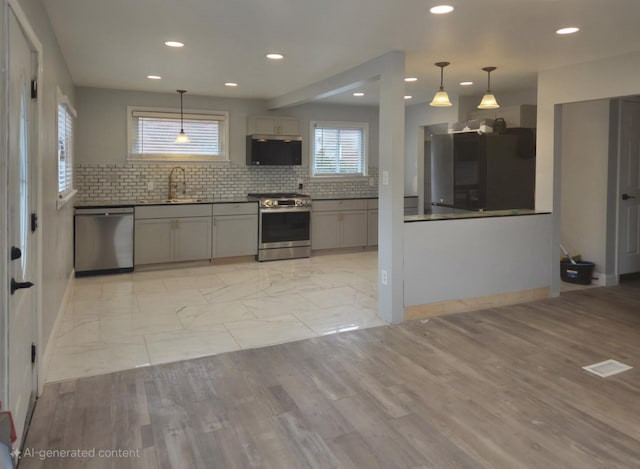 kitchen featuring decorative backsplash, appliances with stainless steel finishes, gray cabinets, a sink, and recessed lighting