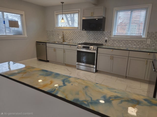 kitchen featuring appliances with stainless steel finishes, a sink, and gray cabinetry