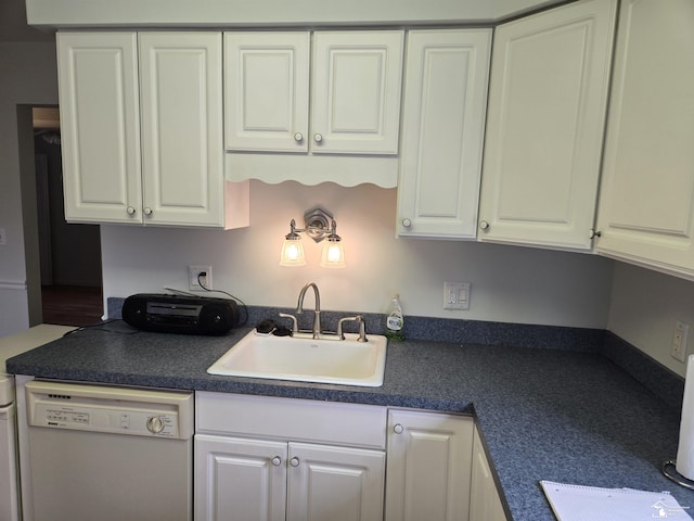 kitchen featuring dark countertops, white cabinetry, dishwasher, and a sink