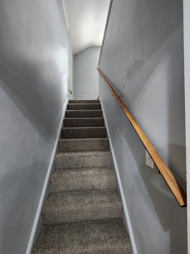 stairs featuring baseboards, carpet flooring, and vaulted ceiling