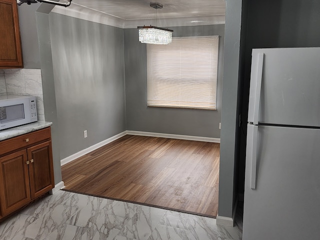 unfurnished dining area featuring baseboards and marble finish floor