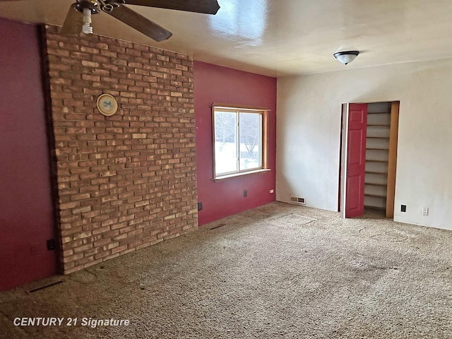 unfurnished room featuring carpet floors, visible vents, and a ceiling fan