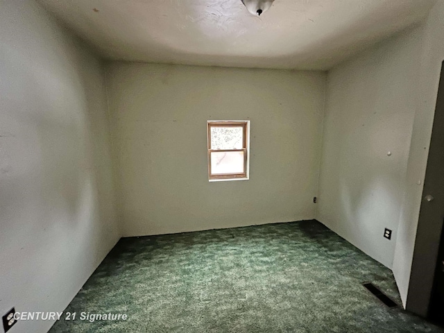 unfurnished room with dark carpet and visible vents