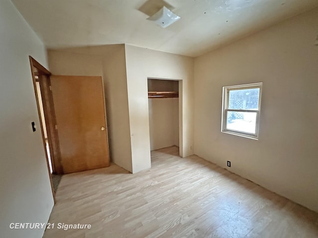 unfurnished bedroom with a closet and light wood finished floors