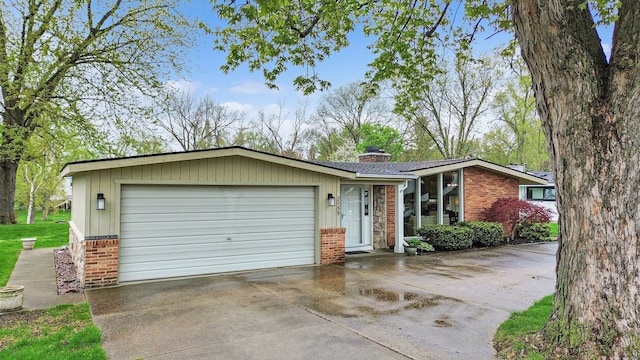2159 Helmsford Dr, Wolverine Lake, MI 48390 - mid-century inspired home with brick siding, a garage, concrete driveway, and a chimney