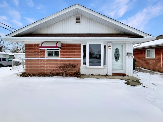 view of front facade with brick siding and fence