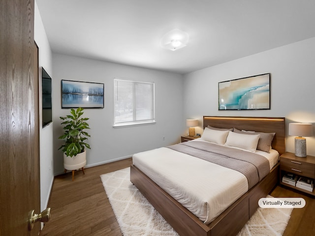 bedroom with wood finished floors and baseboards