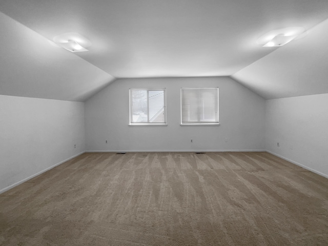 bonus room with lofted ceiling and carpet floors