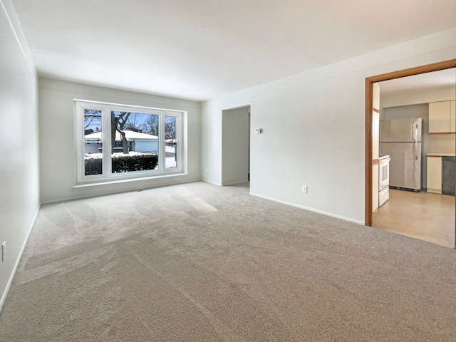 empty room with light carpet and baseboards