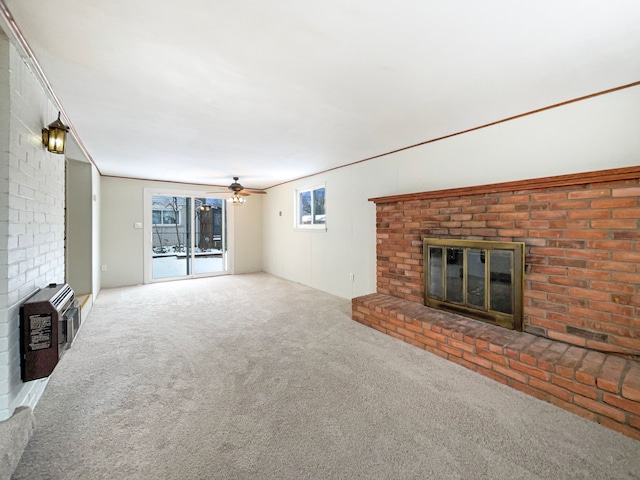 unfurnished living room featuring carpet floors, a fireplace, heating unit, and a ceiling fan