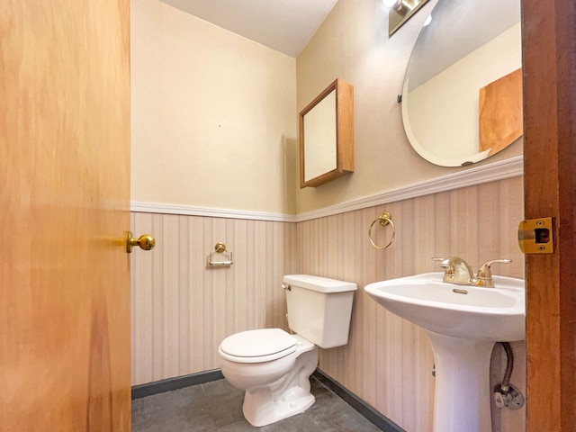 bathroom featuring toilet and wainscoting