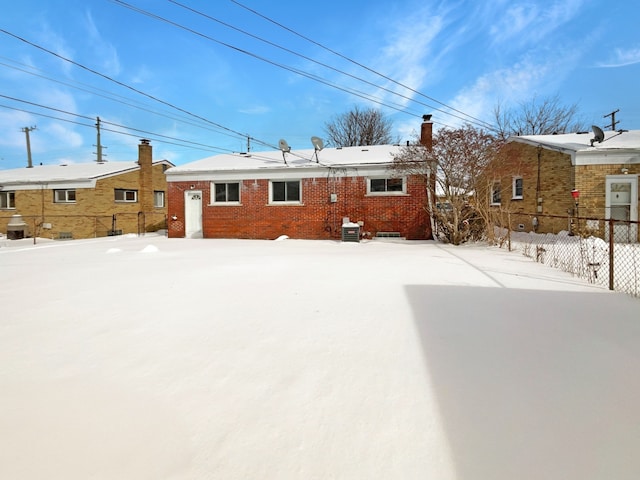 rear view of property with brick siding and fence