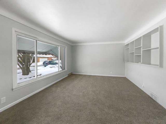 empty room with carpet, visible vents, and baseboards