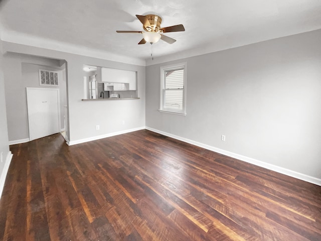 unfurnished living room featuring dark wood-style floors, visible vents, baseboards, and a ceiling fan