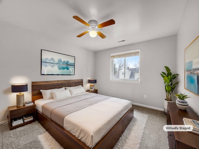 carpeted bedroom featuring a ceiling fan, visible vents, and baseboards