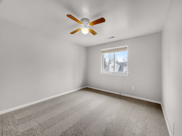 empty room with baseboards, visible vents, ceiling fan, and carpet flooring