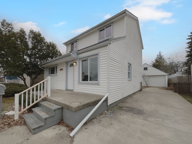 view of front facade with a garage, an outdoor structure, and fence