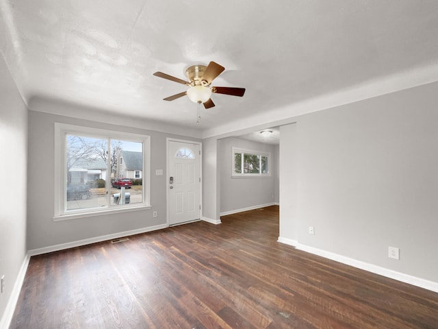 foyer with a ceiling fan, visible vents, baseboards, and wood finished floors